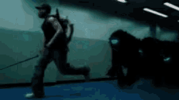 a man is running with a dog on a leash in a dark room
