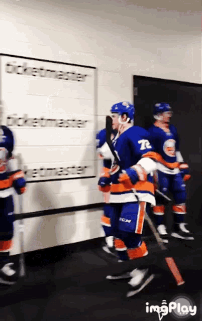 a hockey player with the number 72 on his jersey is holding a hockey stick