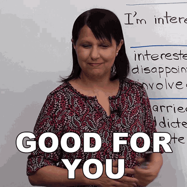 a woman stands in front of a white board that says " good for you "