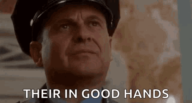 a man in a police uniform is saying `` their in good hands '' while looking up .