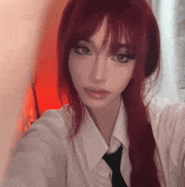 a girl with long red hair is wearing a white shirt and black tie