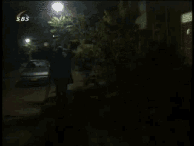 a sbs channel shows a man walking down a dark street