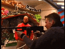 a man in a red jacket is holding a gun in his hand