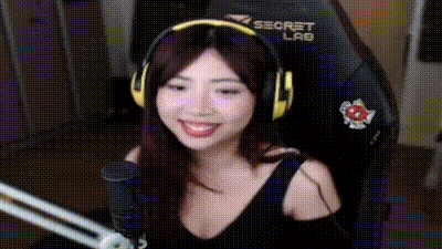 a woman is wearing headphones and smiling while sitting in a chair .