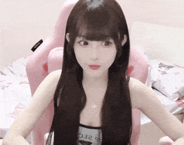 a girl in a pink chair has a necklace that says o2ec on it