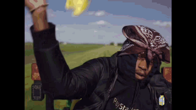 a man wearing a bandana and a black jacket with the word paystar on it