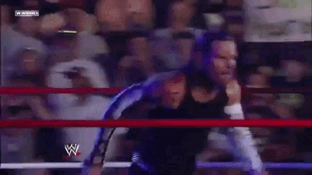 a man in a wrestling ring with a w on the bottom of the screen