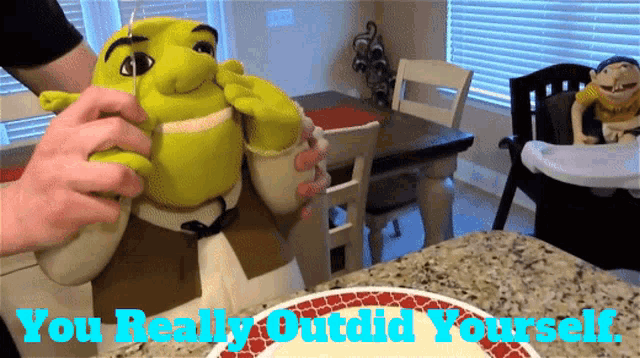a shrek puppet is being held in someone 's hands with the words you really outdid yourself above it