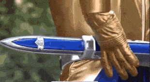 a person wearing gold gloves is holding a sword