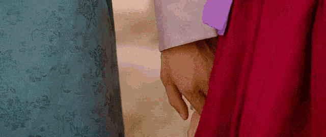 a man and a woman are holding hands while wearing traditional korean clothing .