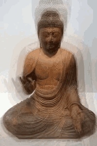 a statue of a buddha in a lotus position with a shadow behind it