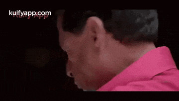 a close up of a man 's face with a red shirt on .