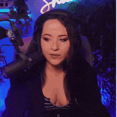 a woman wearing headphones is sitting in front of a microphone ..