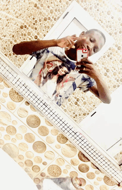 a man taking a picture of himself in a bathroom mirror