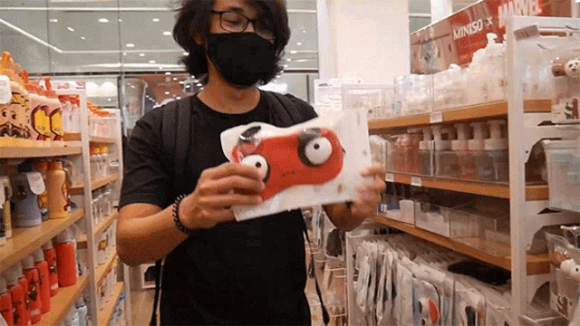 a man wearing a mask is looking at a product in a store