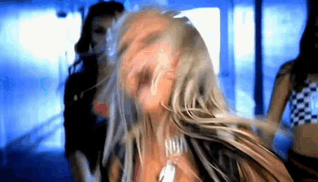a woman with long blonde hair is dancing with another woman