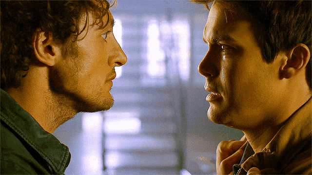 two men are looking at each other and one has a tear coming out of his eye