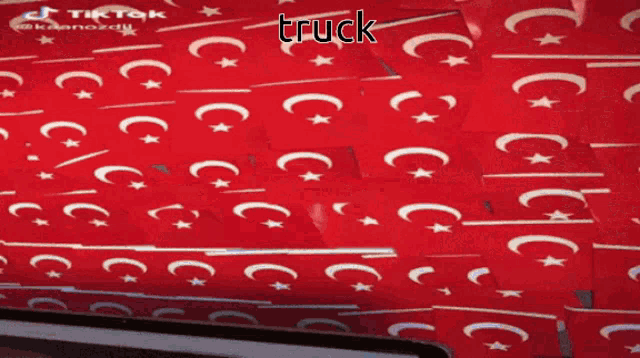 a man is standing in a room with a red wall and the word truck written on it