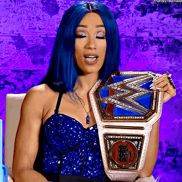 a woman with blue hair is holding a wrestling championship