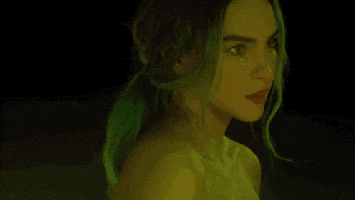 a woman with green hair has a tear coming out of her nose