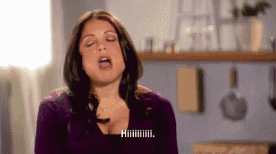 a woman in a purple sweater is making a funny face with her mouth open .