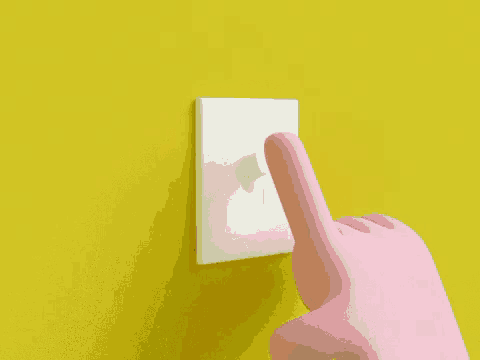 a pink hand is pointing at a white light switch on a yellow wall