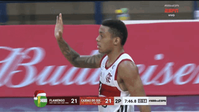 a basketball player giving a high five in front of a budweiser advertisement