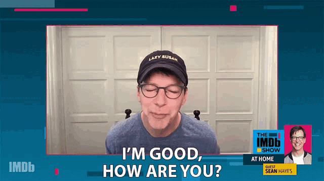 a man wearing a hat that says " lazy susan " is being interviewed on the imdb show at home