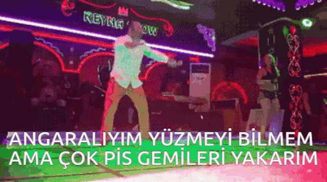 a man is dancing in front of a neon sign that says keyng show