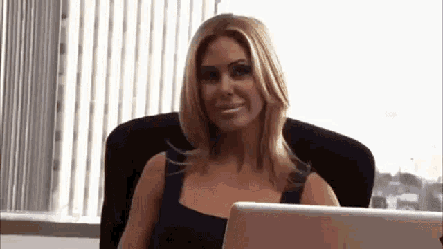 a woman is sitting in front of a laptop computer .