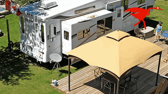 a rv parked in a grassy area with a canopy