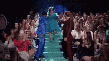 a group of people are dancing in front of a crowd of people .