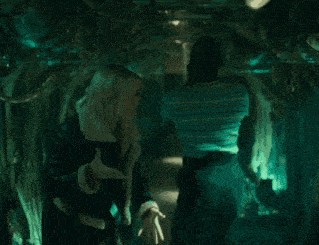 a man is talking to a woman in a dark room .