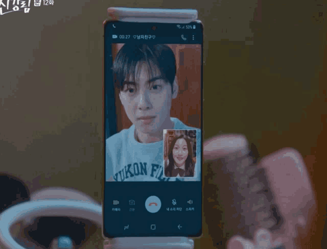 a phone screen shows a man and a woman on a call
