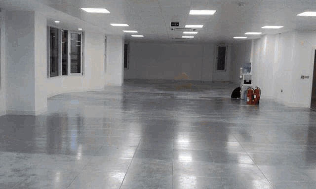 an empty room with a fire extinguisher and a water dispenser