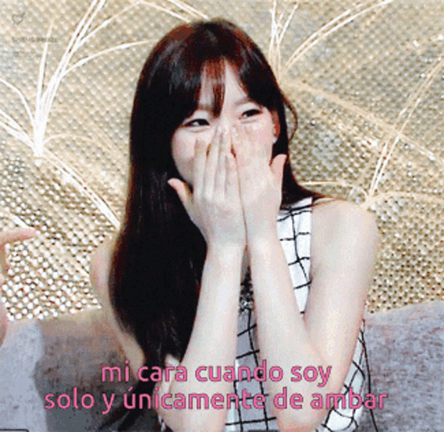 a woman covering her mouth with her hand and the words mi cara cuando soy solo y únicamente de ambar