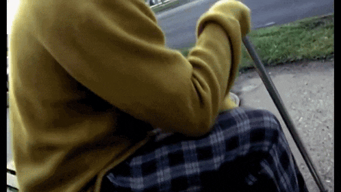a person wearing a yellow sweater and plaid pants