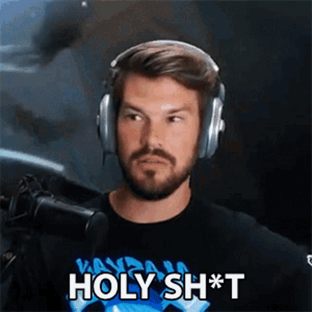 a man wearing headphones says holy sh * t in front of a microphone