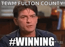a man is making a funny face with the words `` team fulton county #winning '' .