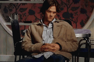a man sitting in a chair with his hands folded
