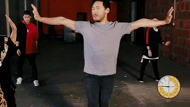 a man with his arms outstretched is standing in front of a clock that shows the time as 4:20
