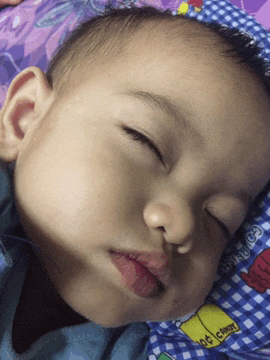 a baby is sleeping on a bed with a blanket that says snoopy