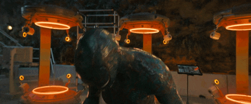 a statue of a dinosaur is surrounded by orange lights and a sign that says ' a ' on it