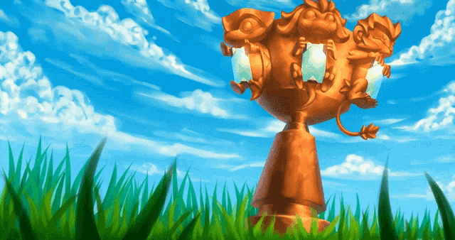 a statue of a lion is in the grass with a blue sky in the background