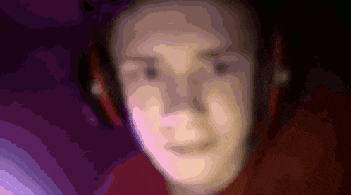 a blurry picture of a person 's face with a purple background
