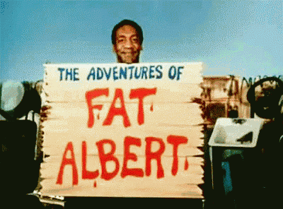a man is holding a sign that says " the adventures of fat albert "