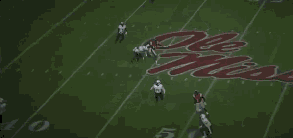 a football player in a red jersey is jumping in the air to catch a pass .