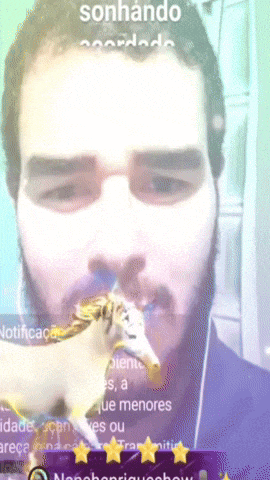 a man with a beard is holding a unicorn in front of his face with the words sonhando written above him