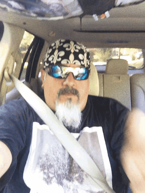 a man with a beard wearing sunglasses and a bandana