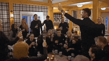 a group of people are sitting around a table with glasses of champagne .
